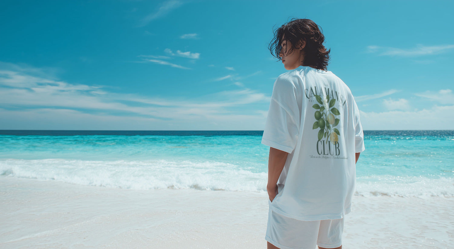 A Filipino standing alone at the beach with a calamansi club botanic shirt in white
