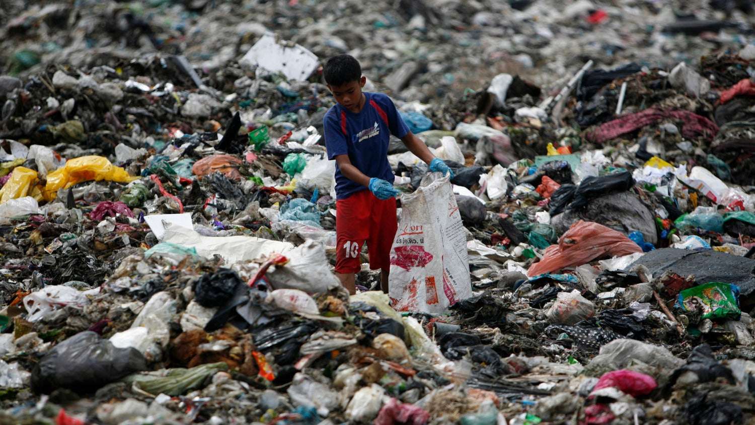 Little filipino boy collecting trash